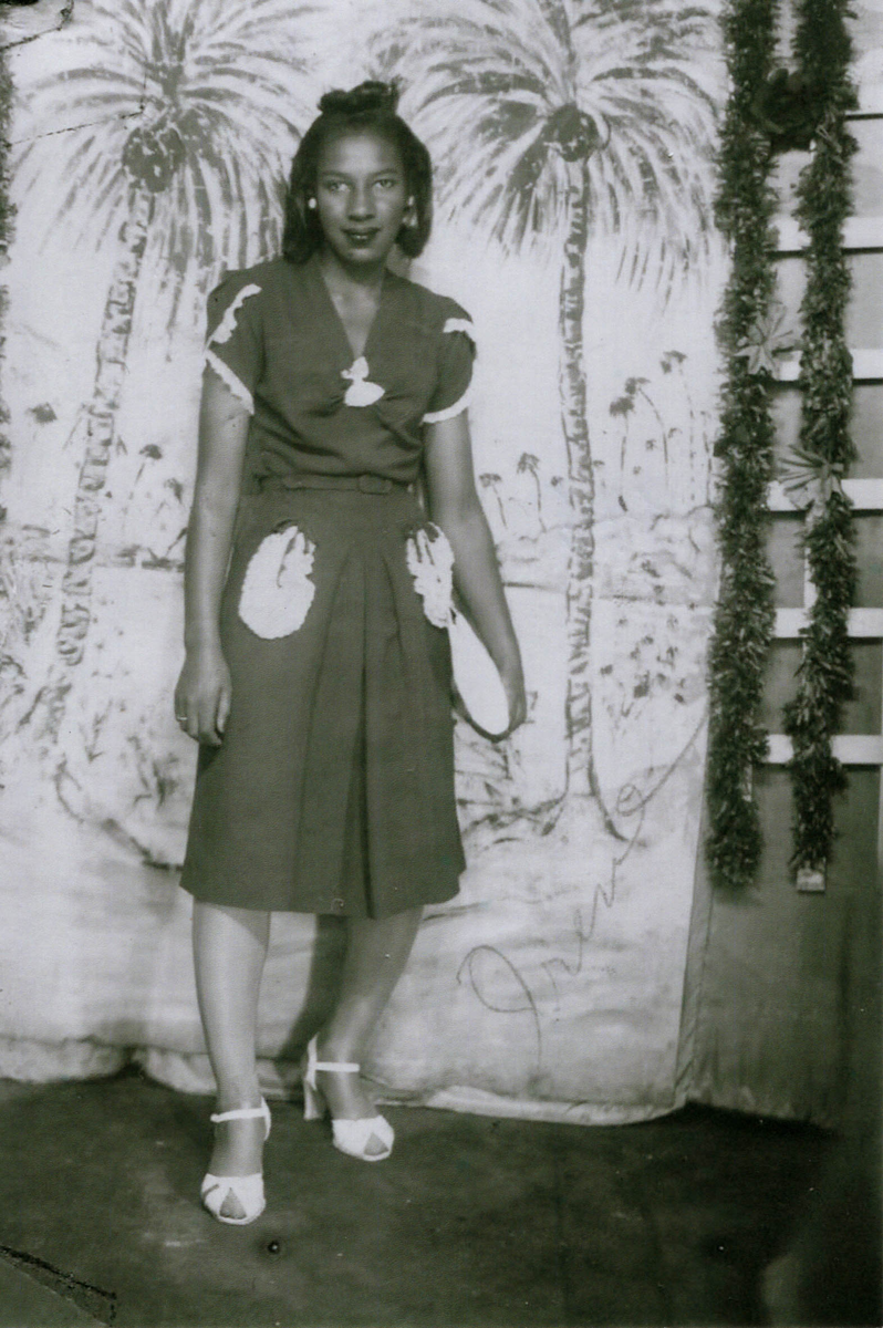 Irene Helen Smith in photo studio (potentially in DC or Baltimore), with palm tree painted backdrop, estimated to be taken in 1946. 